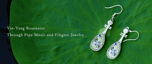 Sterling silver filigree pipa earrings with cloisonné enamel resting on a lotus leaf — handcrafted Chinese cultural jewelry inspired by Dunhuang.
