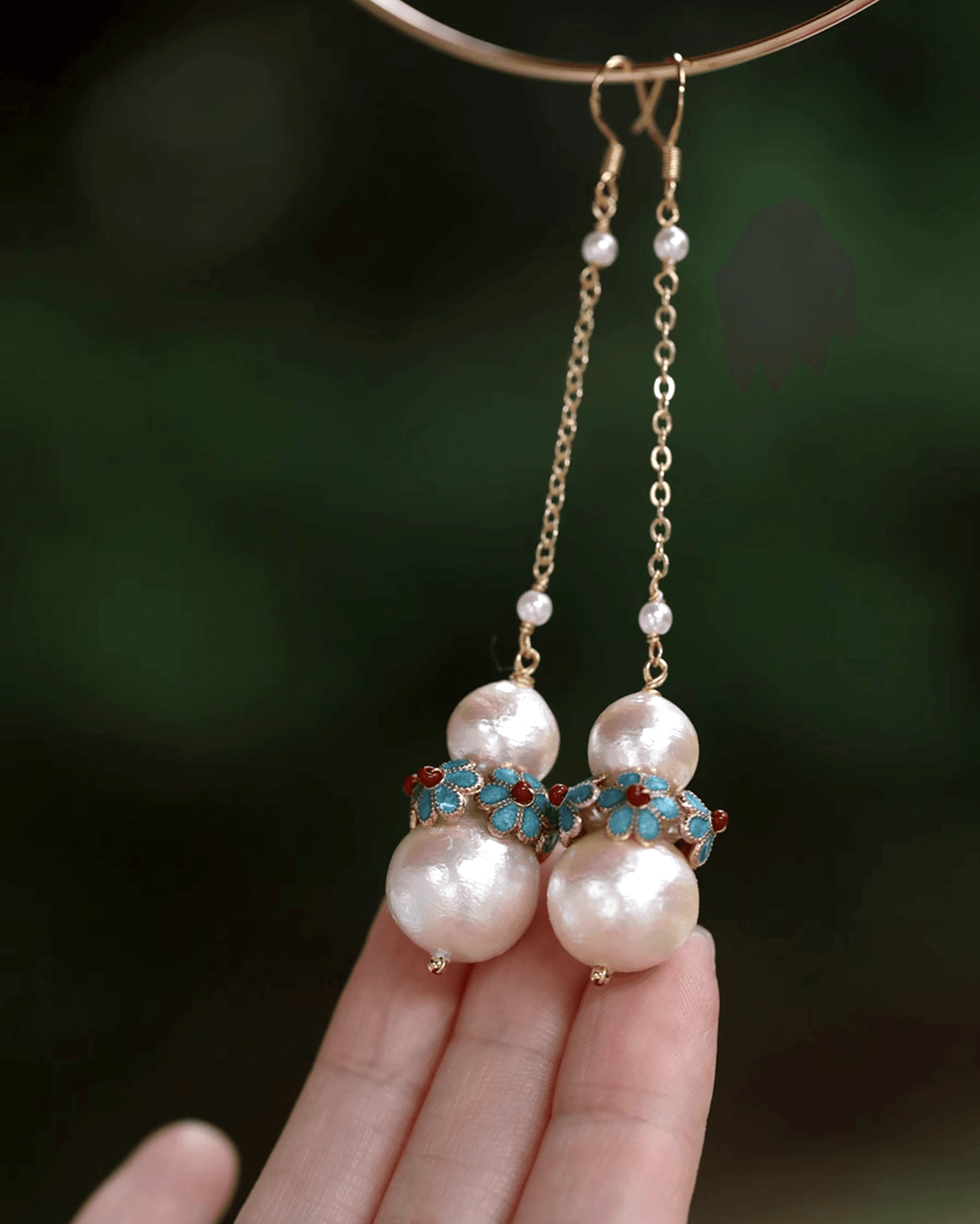 Flat lay of cotton pearl earrings paired with handcrafted cloisonné floral rings featuring turquoise and red enamel