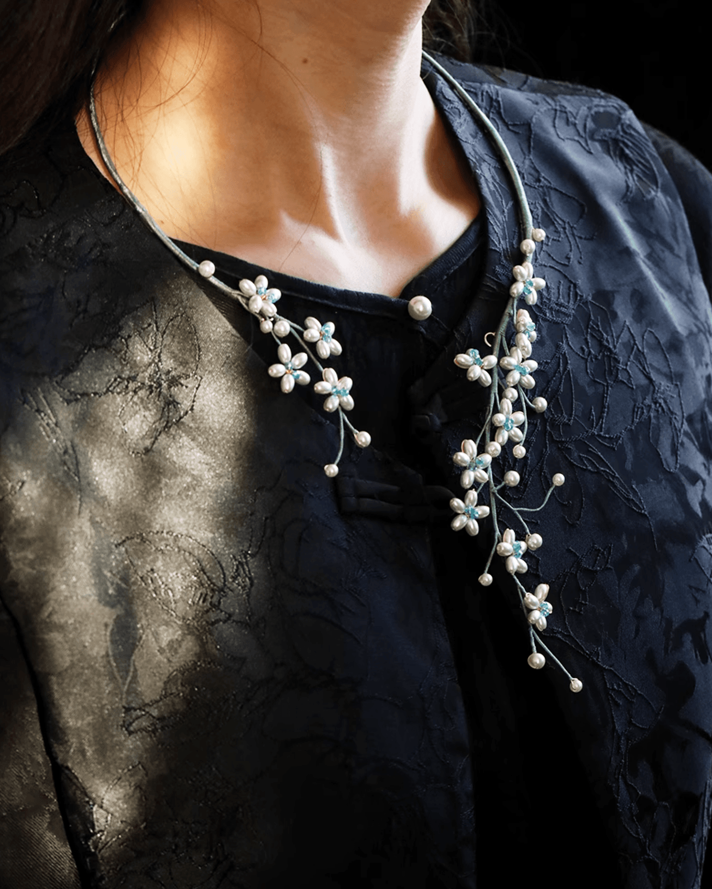 Model wearing pearl choker with high-collared cheongsam, expressing Song Dynasty-inspired grace and refinement