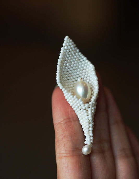 ZolanJewelry Calla Lily natural pearl brooch gently held in hand, highlighting its elegant size and luster.