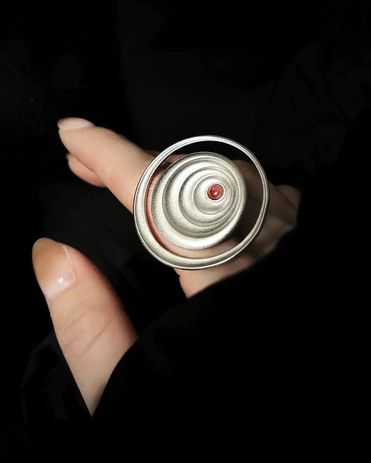 Close-up of wave patterns engraved using intangible cultural heritage metalwork techniques on silver surface