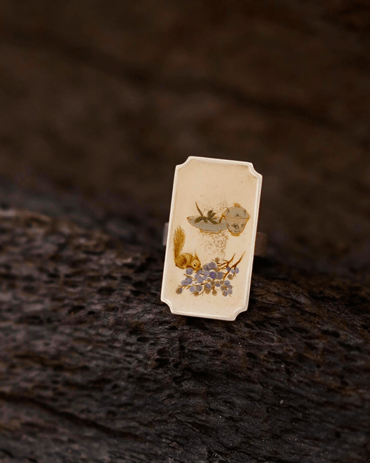 Detailed view of Chinese lacquer ring featuring miniature painting, lacquer finish, and silver setting