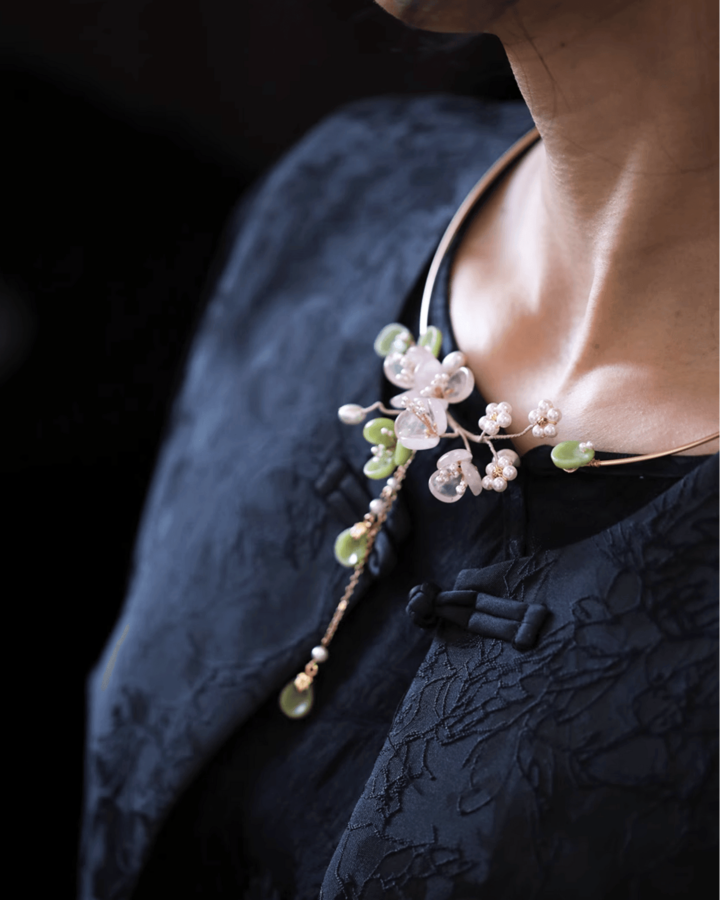 Side view of rose quartz necklace worn with silk blouse, highlighting feminine strength and traditional symbolism