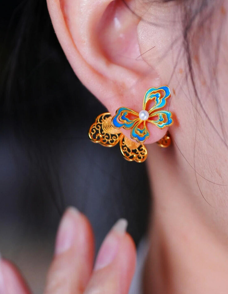Huasi xiangqian pearl butterfly stud earrings worn on ear, handcrafted Chinese filigree jewelry