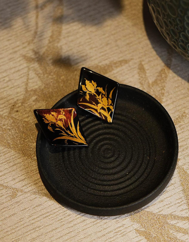 Side angle of the lacquer earrings highlighting the glossy surface and geometric silhouette.