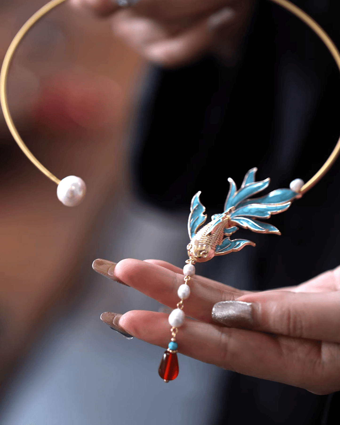 Flat lay of cloisonné enamel choker with filigree silk threads and fish-scale motif, inspired by mythical Chinese peacock fish