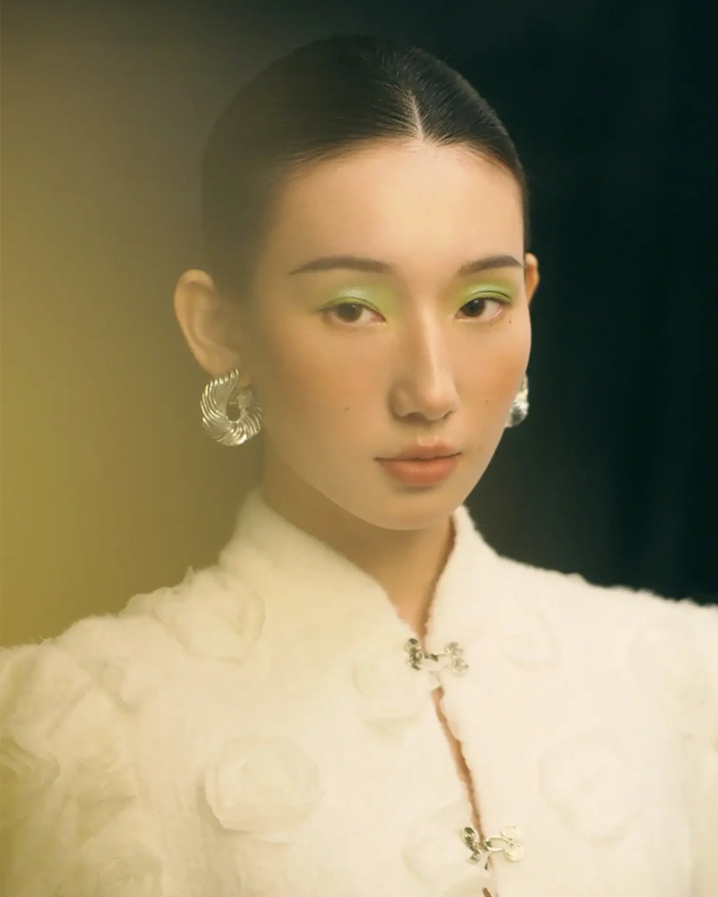 Model wearing hand-folded Möbius silver earrings with minimalist outfit, capturing fluid elegance and timeless rhythm