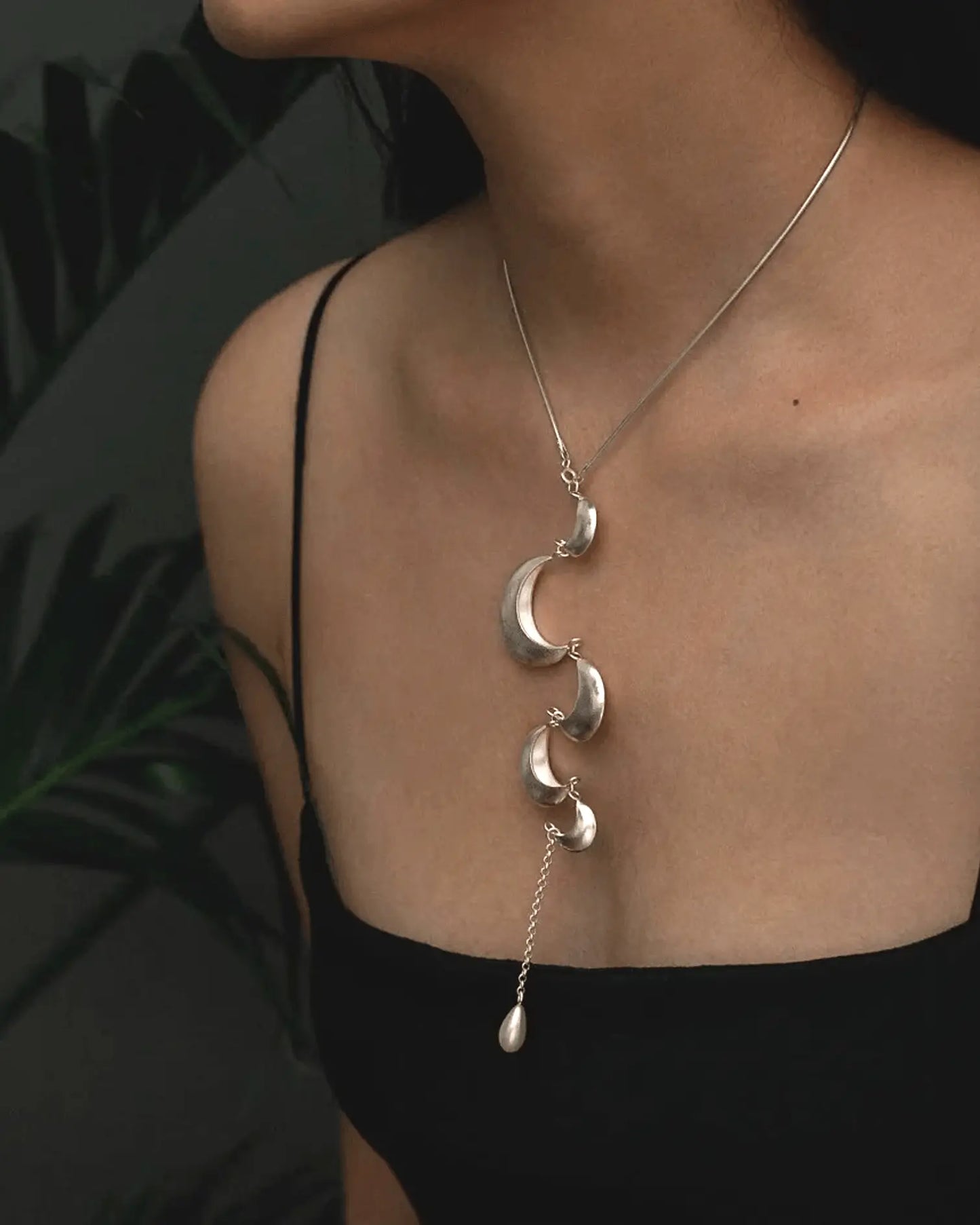 Model wearing moon tassel necklace with simple clothes, capturing lunar rhythm and feminine flow