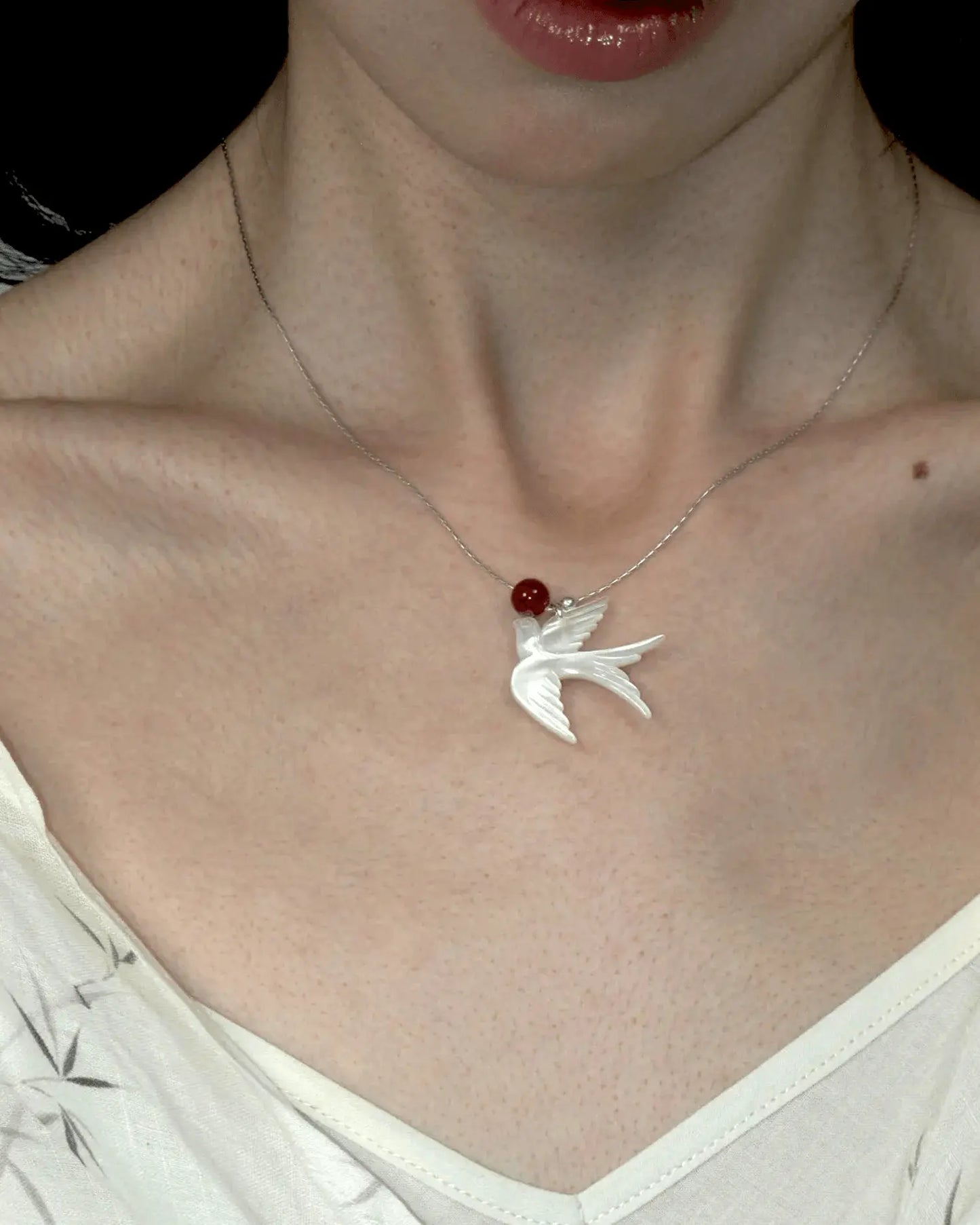 Close-up of necklace styled with minimalist crew neck, highlighting the blend of ethereal and fiery tones