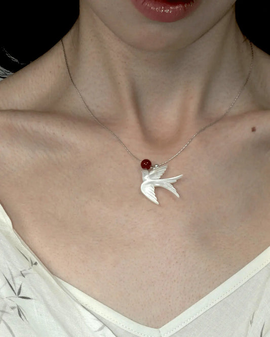 Close-up of necklace styled with minimalist crew neck, highlighting the blend of ethereal and fiery tones