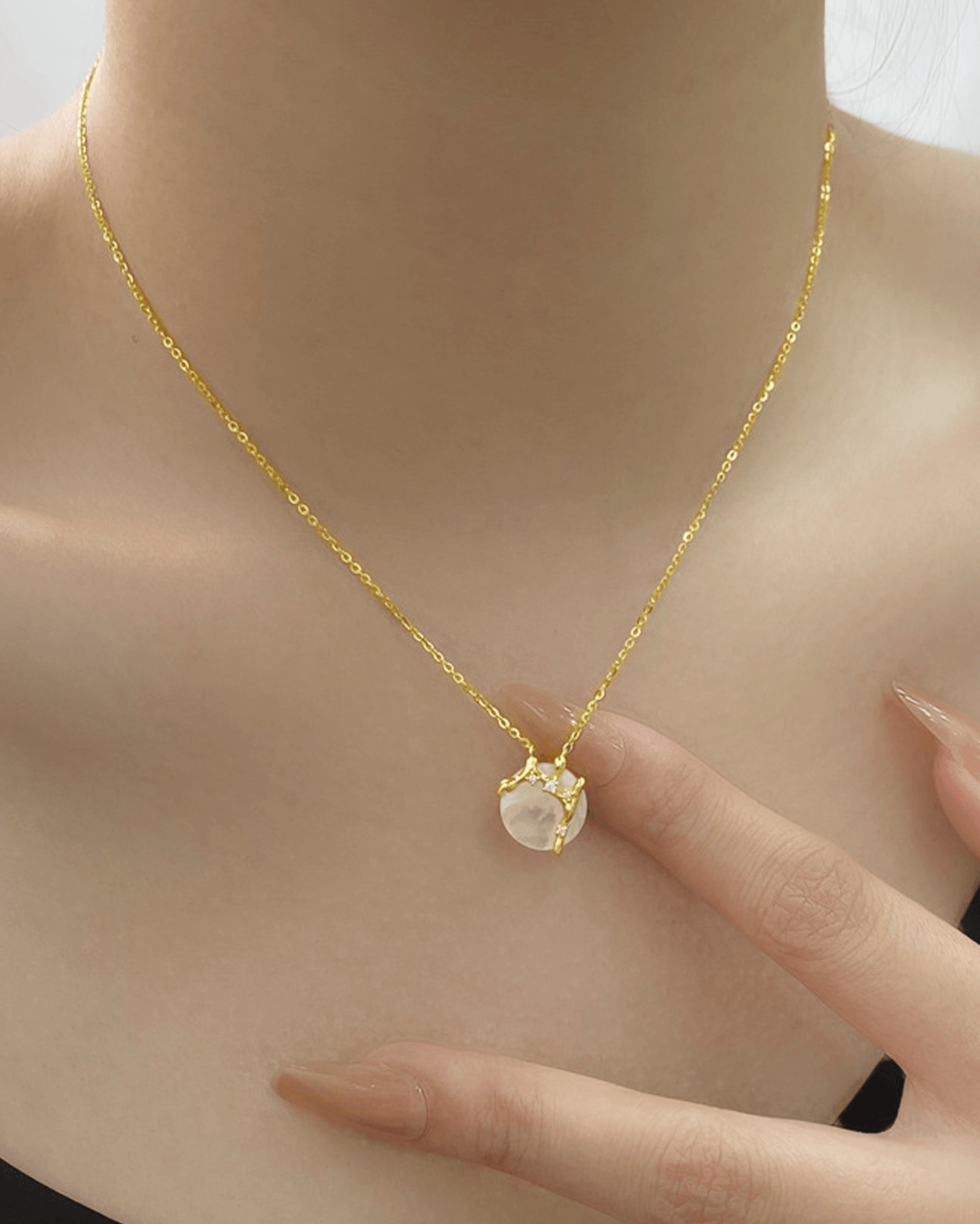Elegant evening look featuring moon necklace paired with black-tie dress, highlighting celestial shimmer