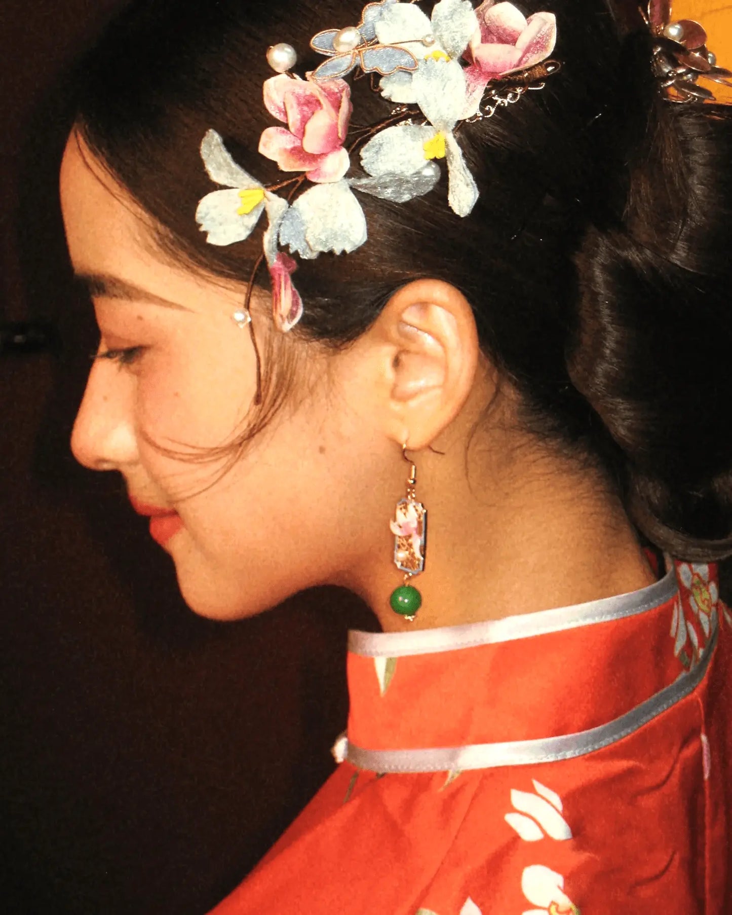 Side view of enamel earrings worn at a wedding ceremony, glimmering like morning petals
