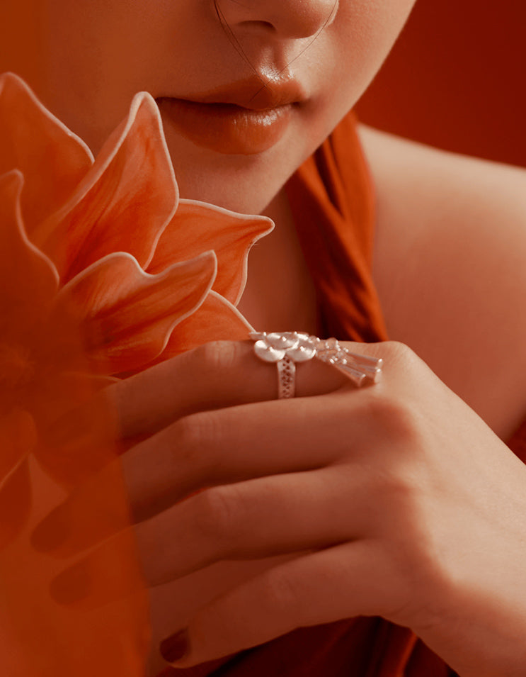 Close-up of ZolanJewelry silver lotus bell statement ring, silver bells gently hanging and catching light, conveying soft movement and ritual depth