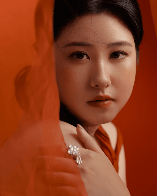 Model wearing Miao silver lotus ring with raw silk shawl, expressing feminine strength and ancestral charm