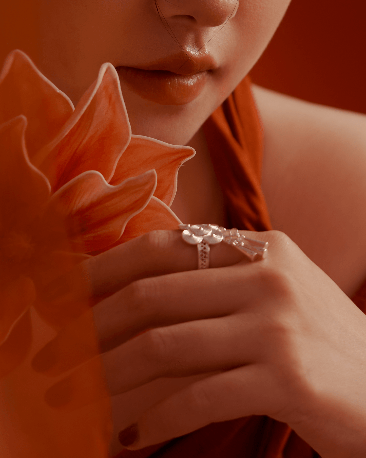 Close-up of ring on hand, silver bells gently hanging and catching light, conveying soft movement and ritual depth