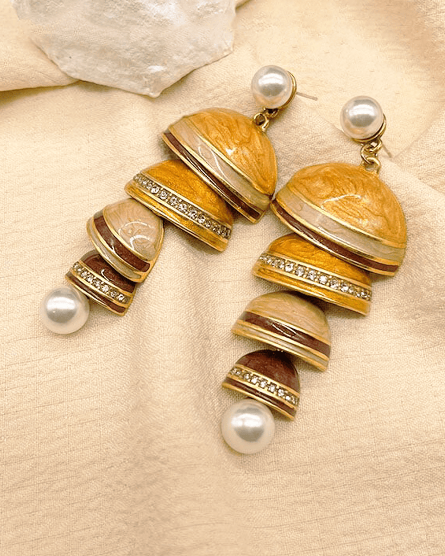 Flat lay of cloisonné pearl earrings with Tibetan-inspired silver chimes and mother-of-pearl beads, reflecting Song Dynasty aesthetics