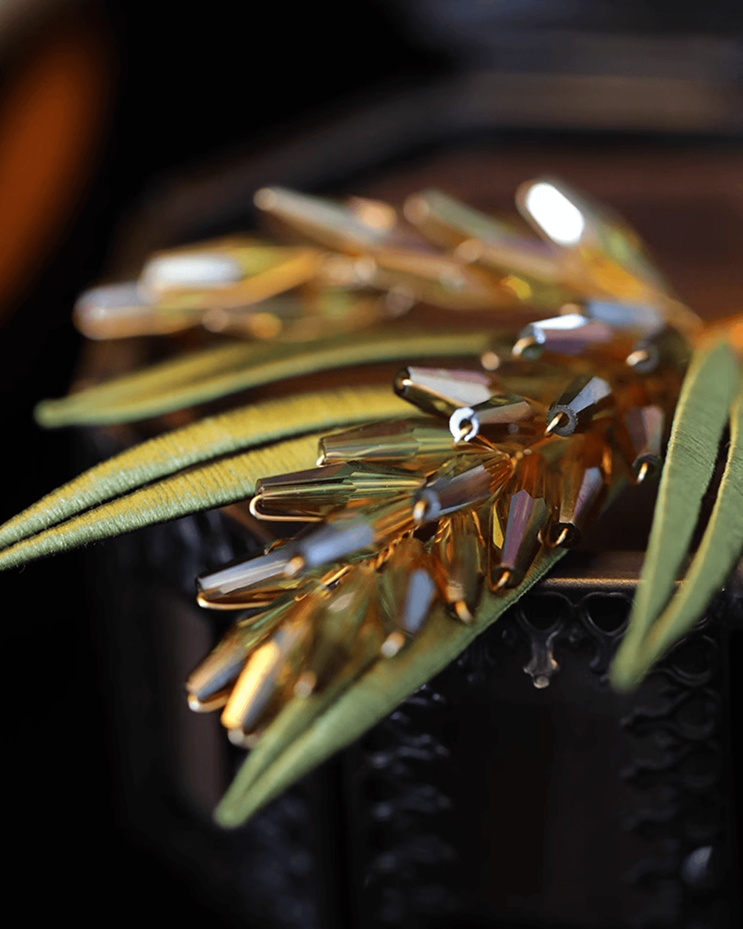 Artisan hands weaving silk threads on brooch frame, illustrating centuries-old craftsmanship