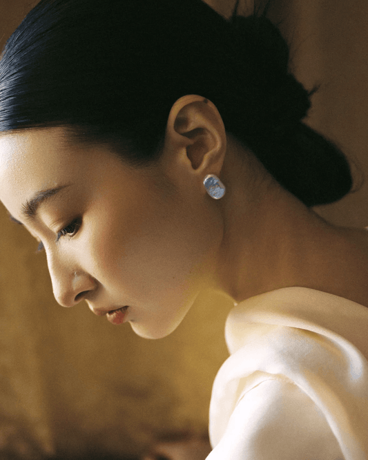 Model wearing baroque pearl earrings with slick minimalist outfit, modern interpretation of yin-yang duality