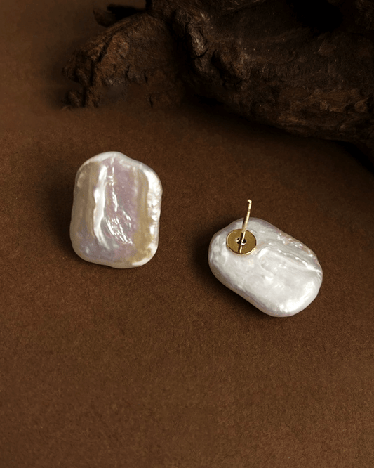 Detail shot of hand-filed silver frame cradling organic-shaped pearl, emphasizing Wabi-sabi imperfection