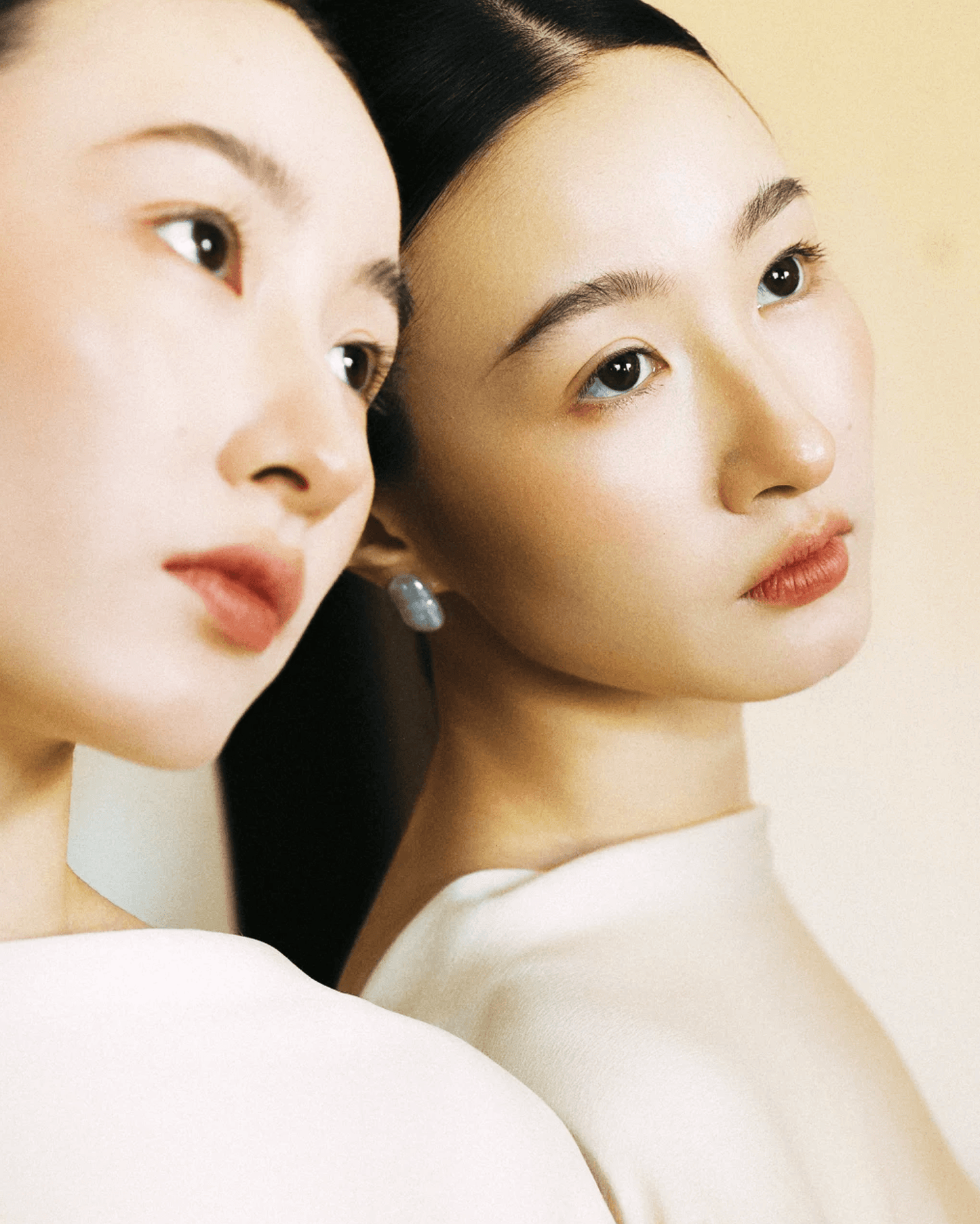 Side view of earrings styled for evening event, baroque pearls glowing under soft lighting
