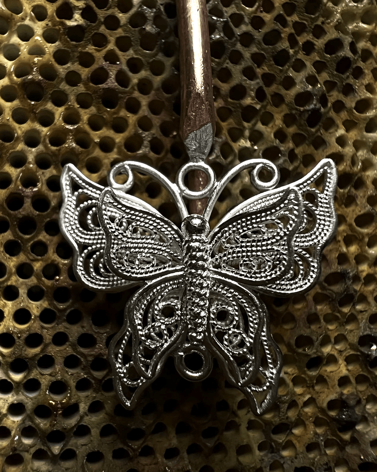 Detail of ergonomic silver hook and lightweight openwork design for sensitive ears