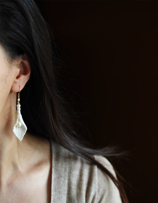 Model wearing ZolanJewelry handwoven calla lily pearl earrings, radiating elegance and grace.