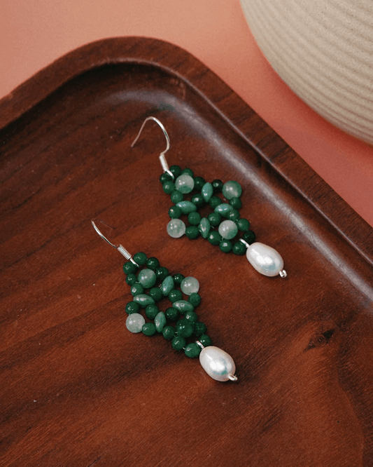 Close-up of translucent green aventurine stones cradled in cotton thread, inspired by ancient Chinese knot vows