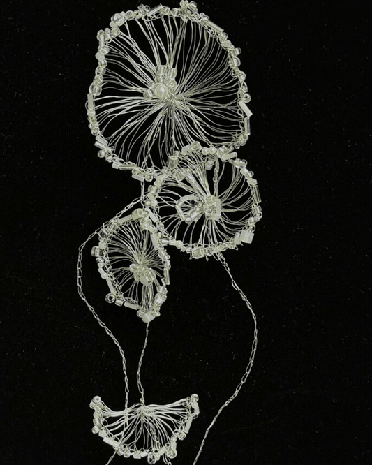 Detail of ombré glass beads shimmering along sculptural wirework, evoking oceanic light play