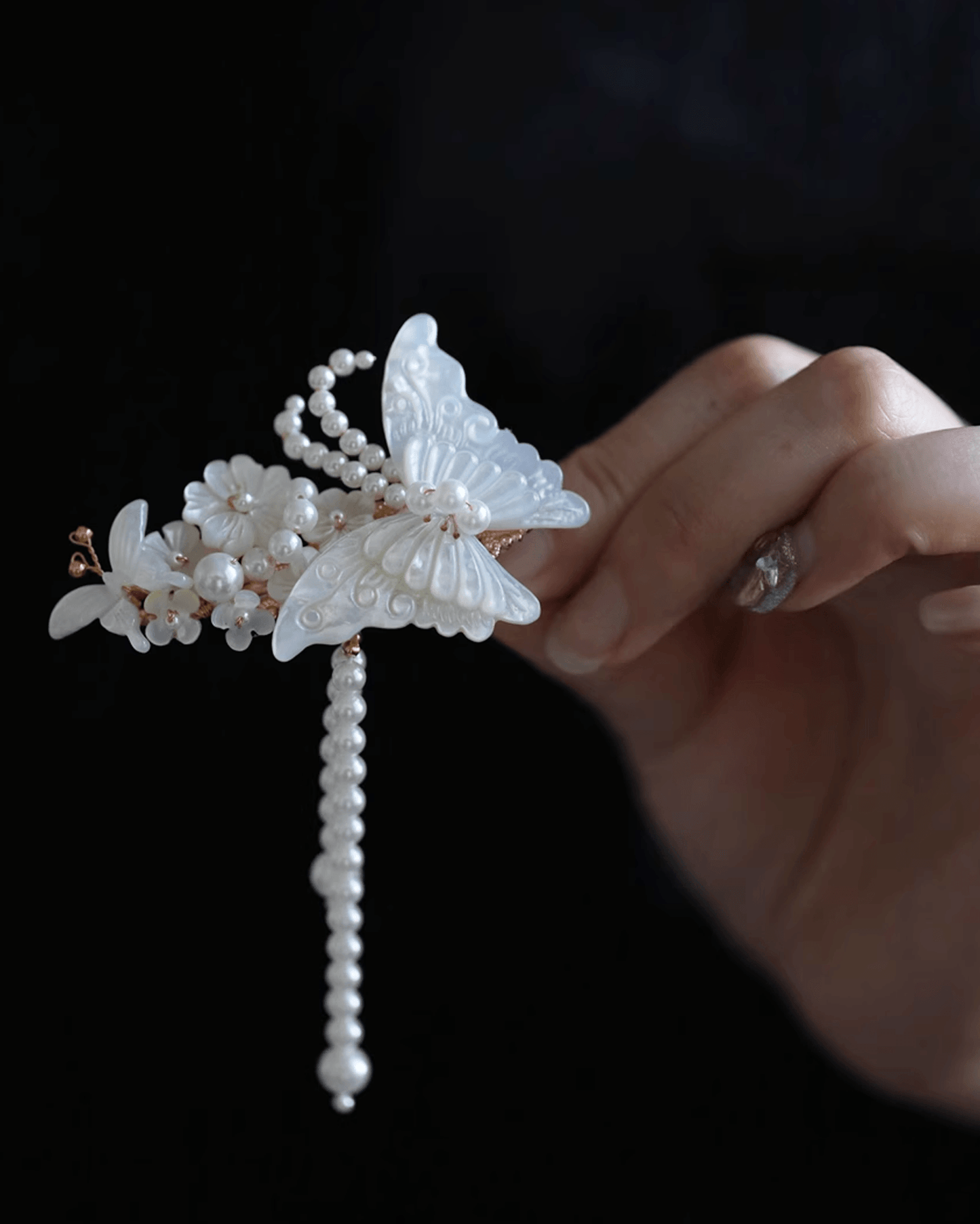 Flat lay of iridescent butterfly hair clip hand-carved from natural mother-of-pearl with silver tassels, inspired by Liang Shanbo and Zhu Yingtai legend