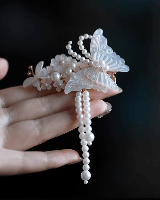 Close-up of delicate 0.3 mm carved mother-of-pearl wings showing natural iridescence and shimmer;Detail shot of silver tassels attached to butterfly wings, creating elegant motion in hair accessories