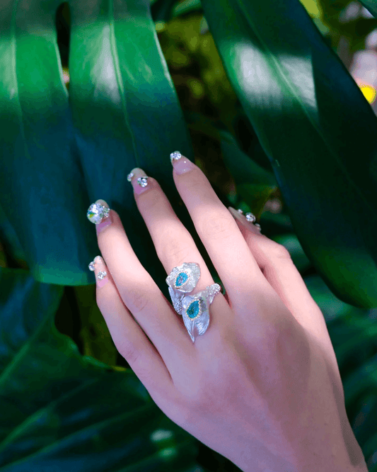 Side view of blue topaz ring on finger, reflecting light with elegant shimmer against minimalist outfit