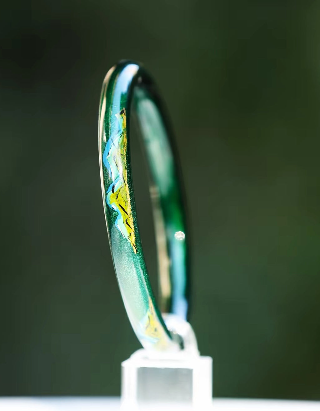 A Thousand Li Chinese lacquer bangle in deep green with luminous golden landscape-inspired details