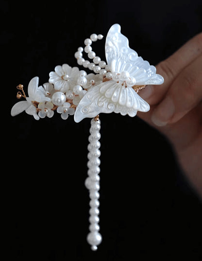 Flat lay of iridescent butterfly hair clip hand-carved from natural mother-of-pearl with silver tassels, inspired by Liang Shanbo and Zhu Yingtai legend