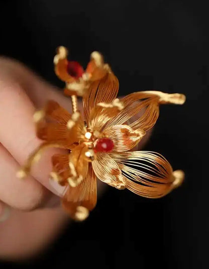 Detailed view of a handcrafted gold pear blossom filigree brooch with delicate openwork petals.