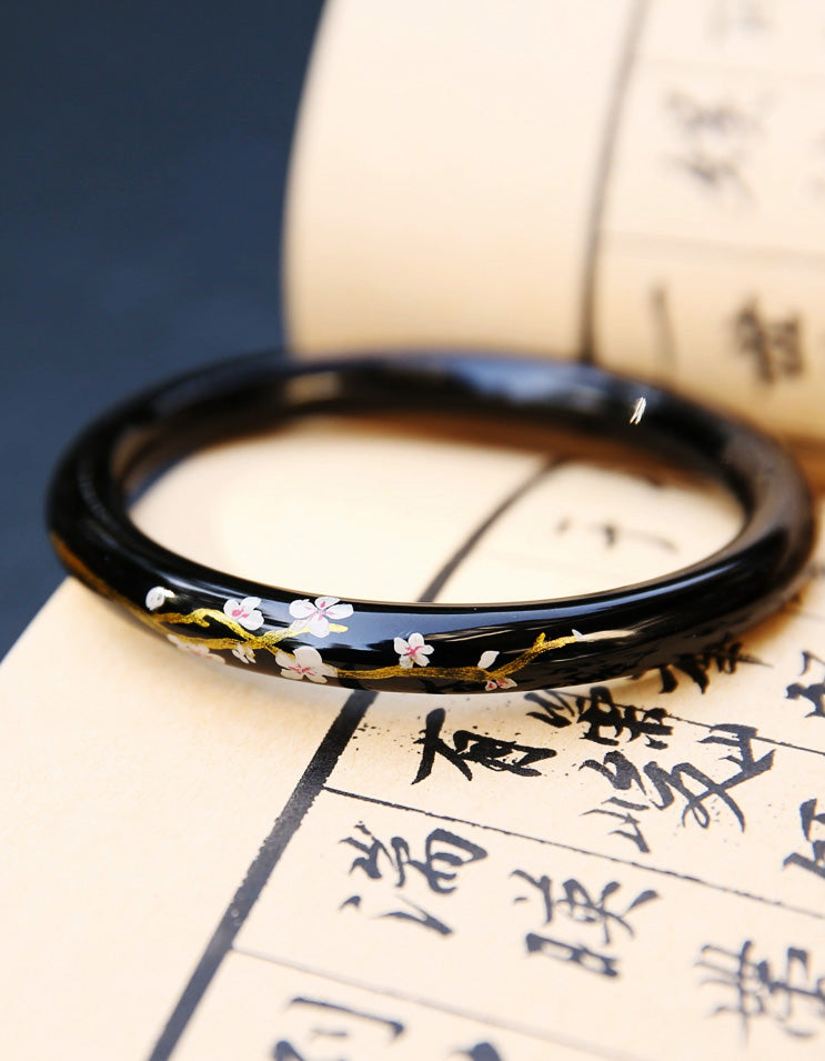 Chinese lacquer bangle featuring sakura symbolism, hand-applied gold detailing, and refined artisanal finish