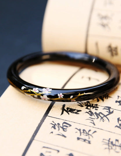 Chinese lacquer bangle featuring sakura symbolism, hand-applied gold detailing, and refined artisanal finish