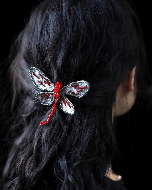 Side view of clip in half-up hairstyle, dragonfly wings catching the light with iridescent shimmer