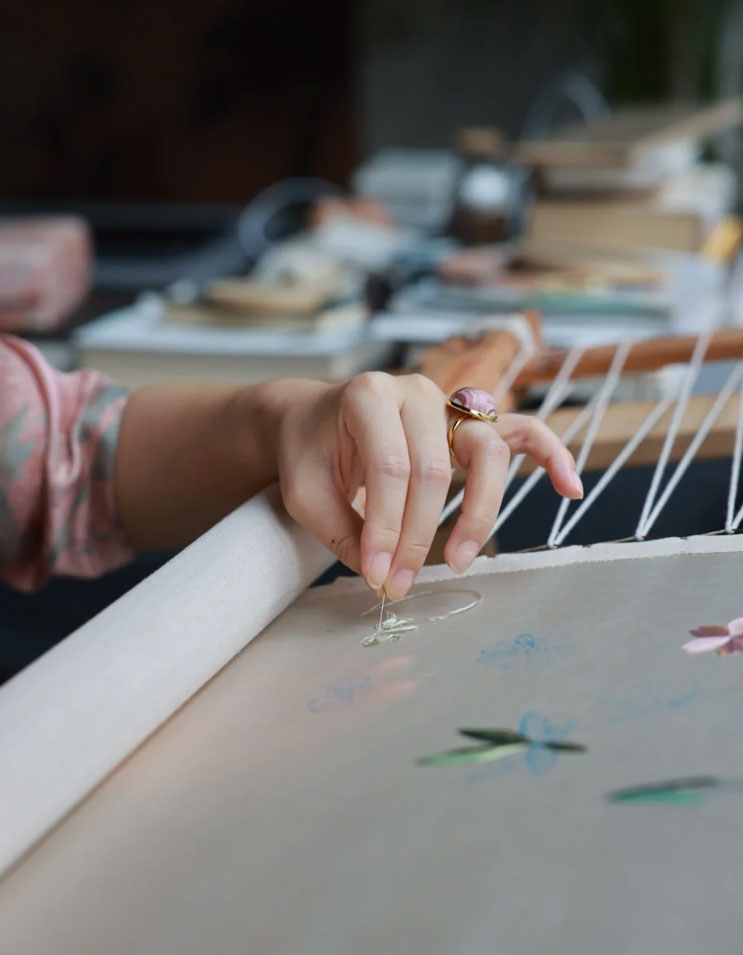 Detailed embroidery artwork on fabric, featuring delicate stitches and intricate patterns that highlight traditional craftsmanship.