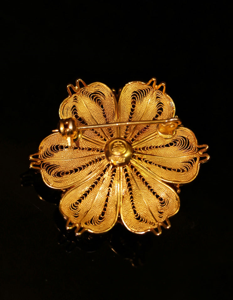 chinese filigree pearl brooch close up, huasi xiangqian filigree inlay detail, gold and silver filigree texture, artisan handmade jewelry