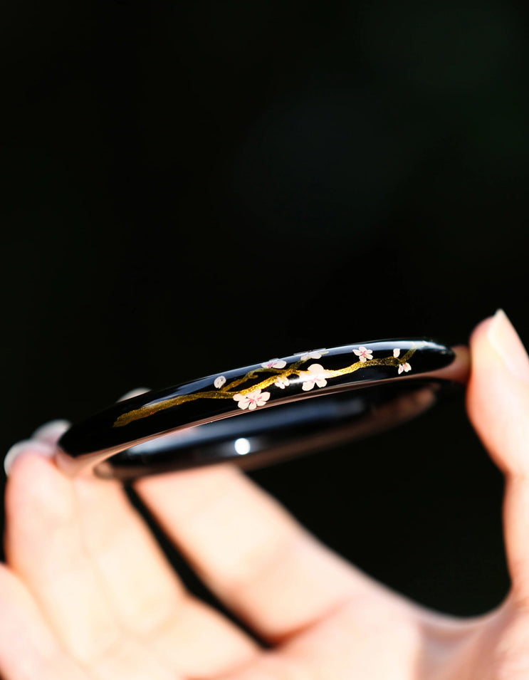 Close-up of gold-leaf lacquer surface inspired by cherry blossom petals in Chinese lacquer art jewelry