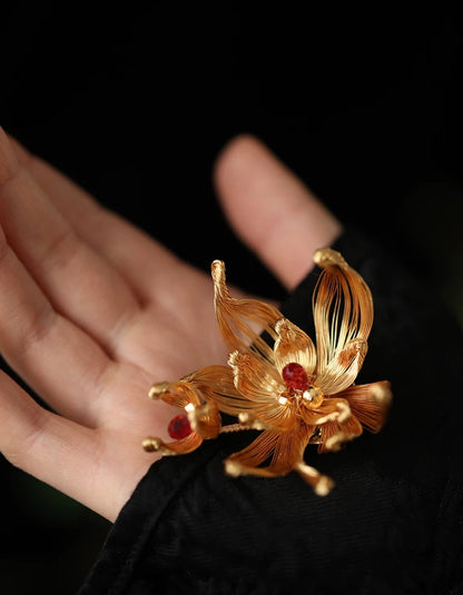 Gold pear blossom brooch in fine filigree displayed on model for an elegant, refined outfit.