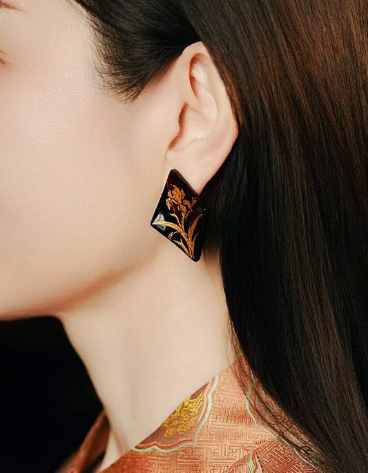 Model wearing the diamond-shaped iris lacquer earrings, showing scale and natural styling.