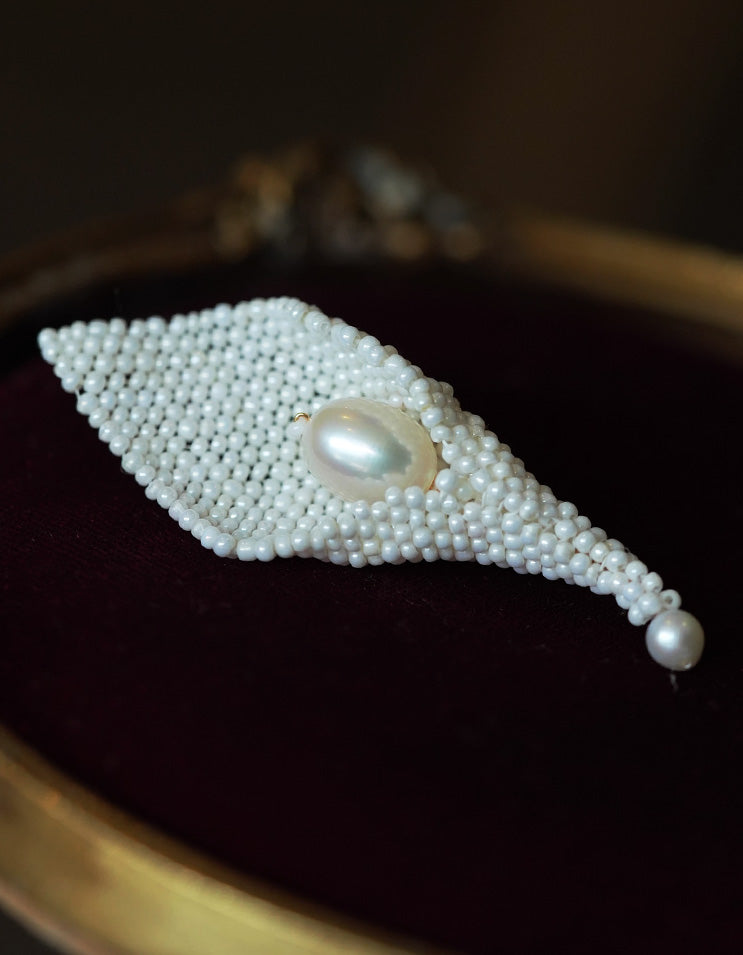 Close-up of ZolanJewelry Calla Lily brooch showing the smooth natural pearl and fine filigree texture.