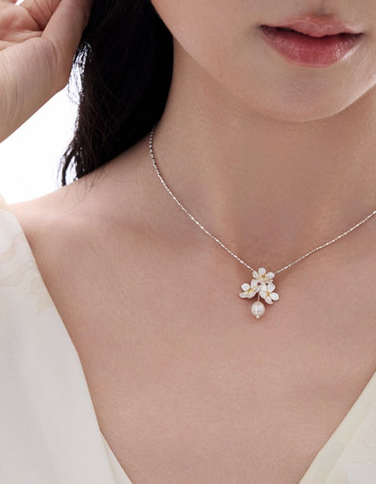 Detailed view of the jasmine-inspired sterling silver pendant paired with a natural freshwater pearl.