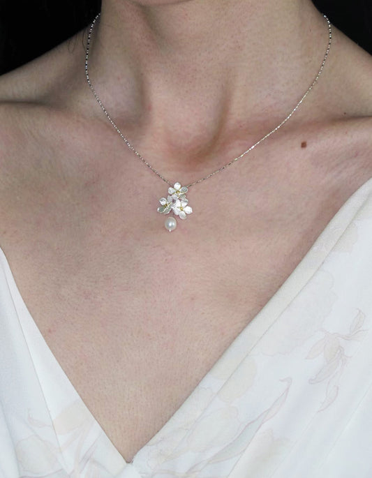 Model wearing a jasmine cluster sterling silver necklace with a freshwater pearl, minimalist collarbone chain.