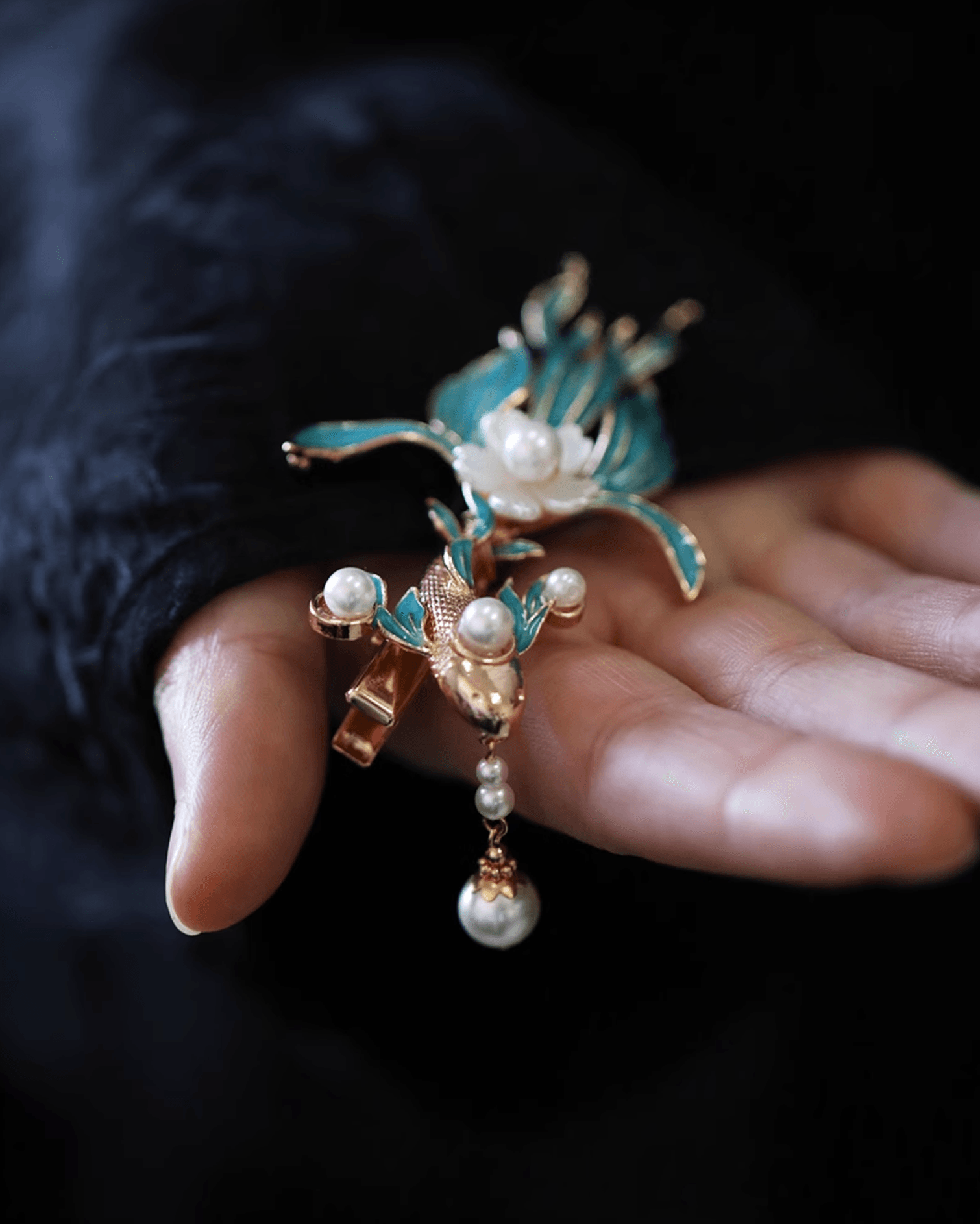 Detail shot of imitation pearls and hand-painted enamel blossoms on elegant hair clip