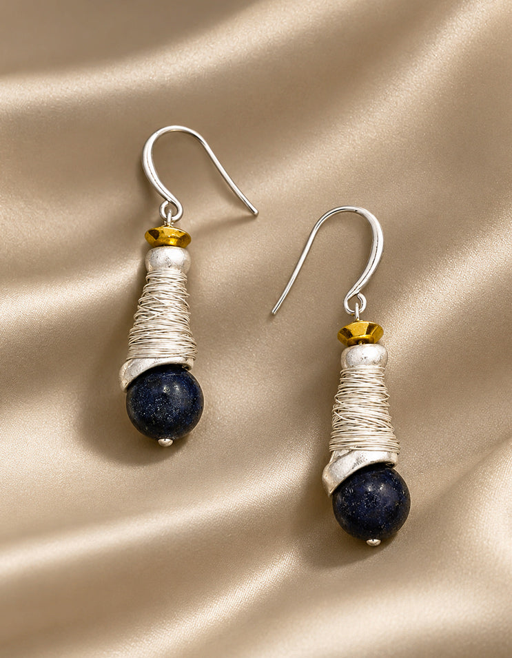 Detail of natural lapis lazuli stone glowing with deep celestial blue, set within hand-crafted silver spiral