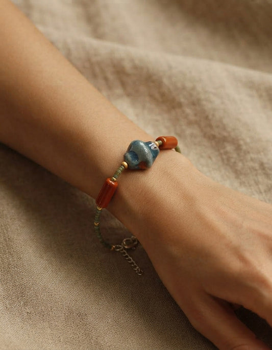 Model wearing a handcrafted Chinese ceramic bracelet by ZolanJewelry, featuring kiln-fired porcelain beads and contemporary Chinese jewelry design.