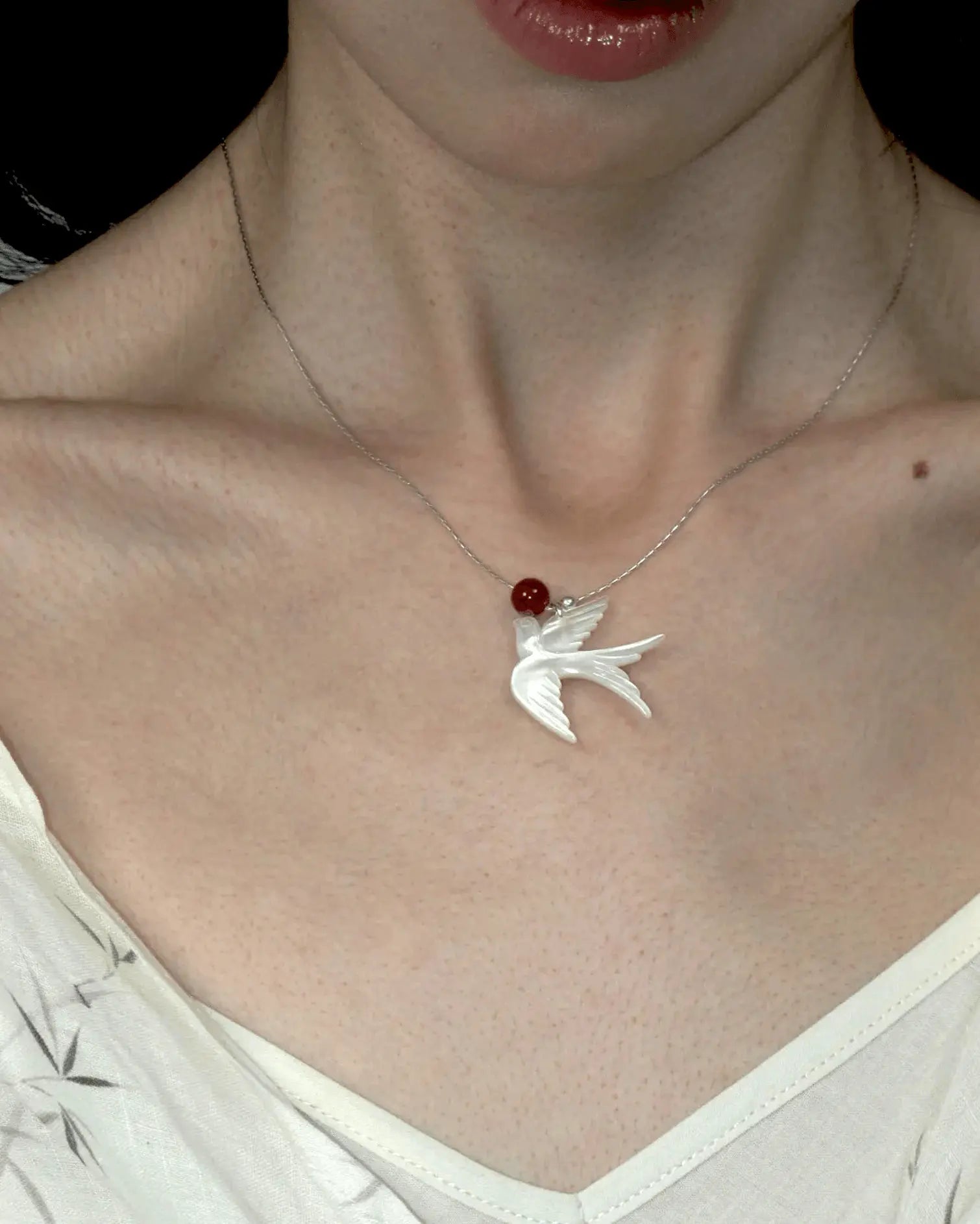 Close-up of necklace styled with minimalist crew neck, highlighting the blend of ethereal and fiery tones