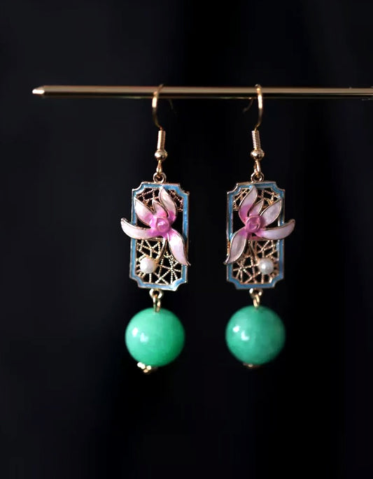 Inspired by Song Dynasty celadon, these handcrafted earrings feature cloisonné enamel orchids and jade drops. A poetic fusion of Chinese glaze aesthetics.